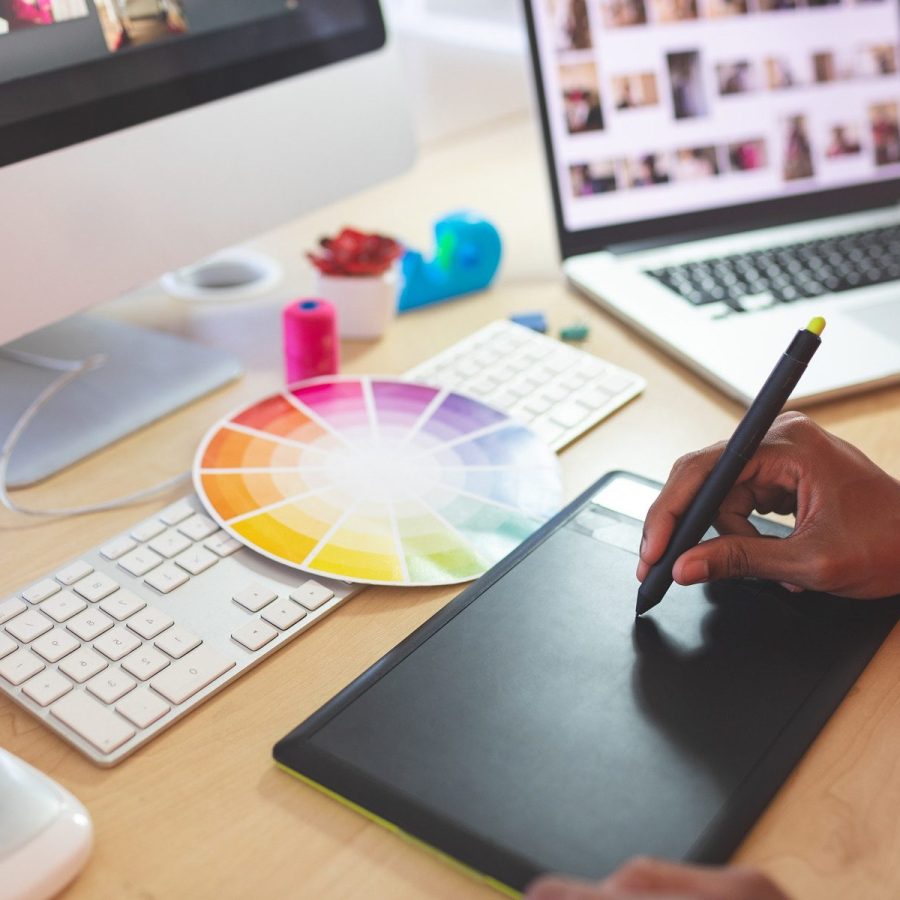 Female graphic designer using graphic tablet at desk