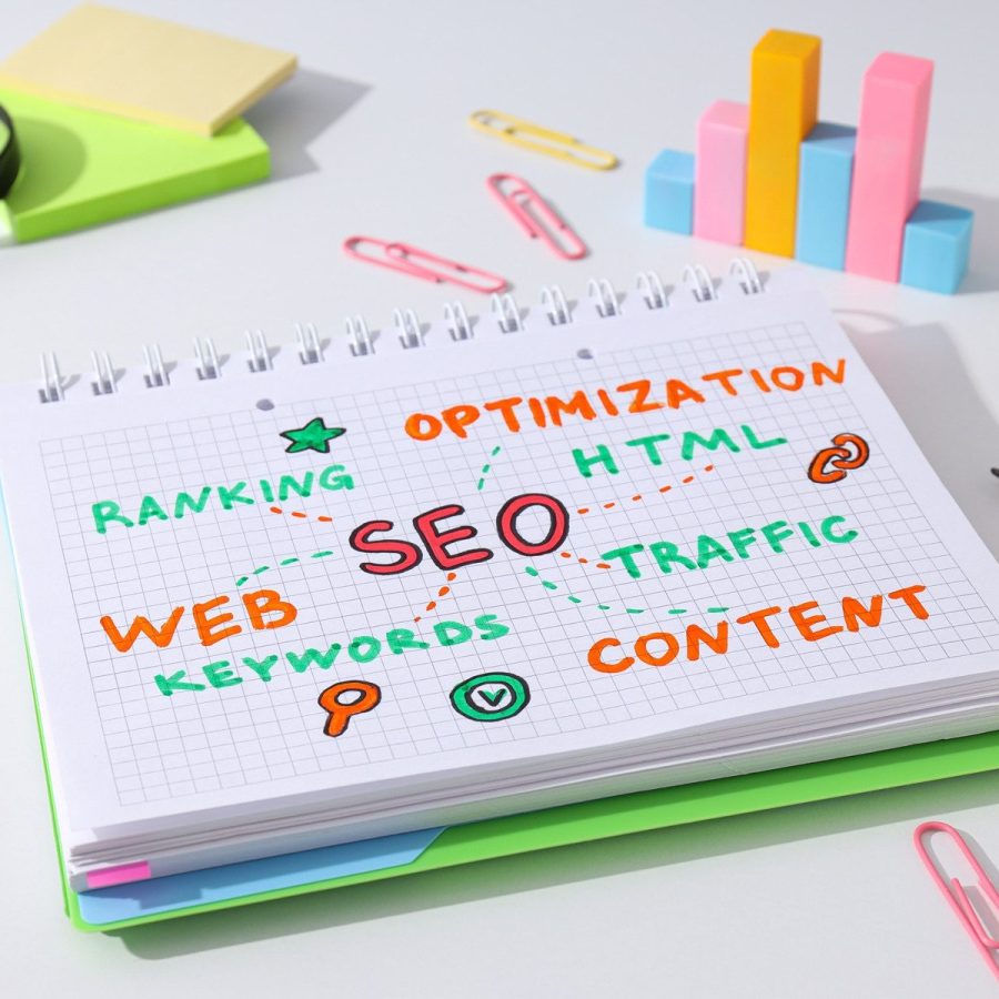 Notepad with diagram, magnifying glass and stationery on white background, close up