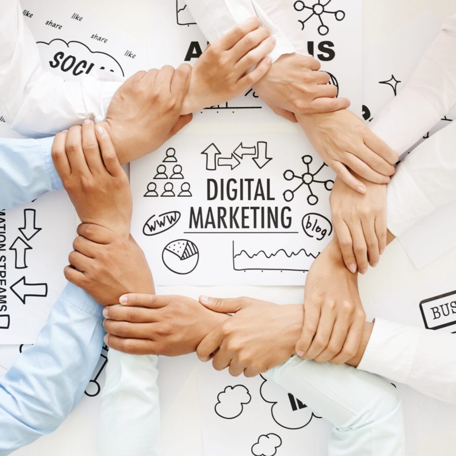 Business team making ring of hands above digital marketing drawing